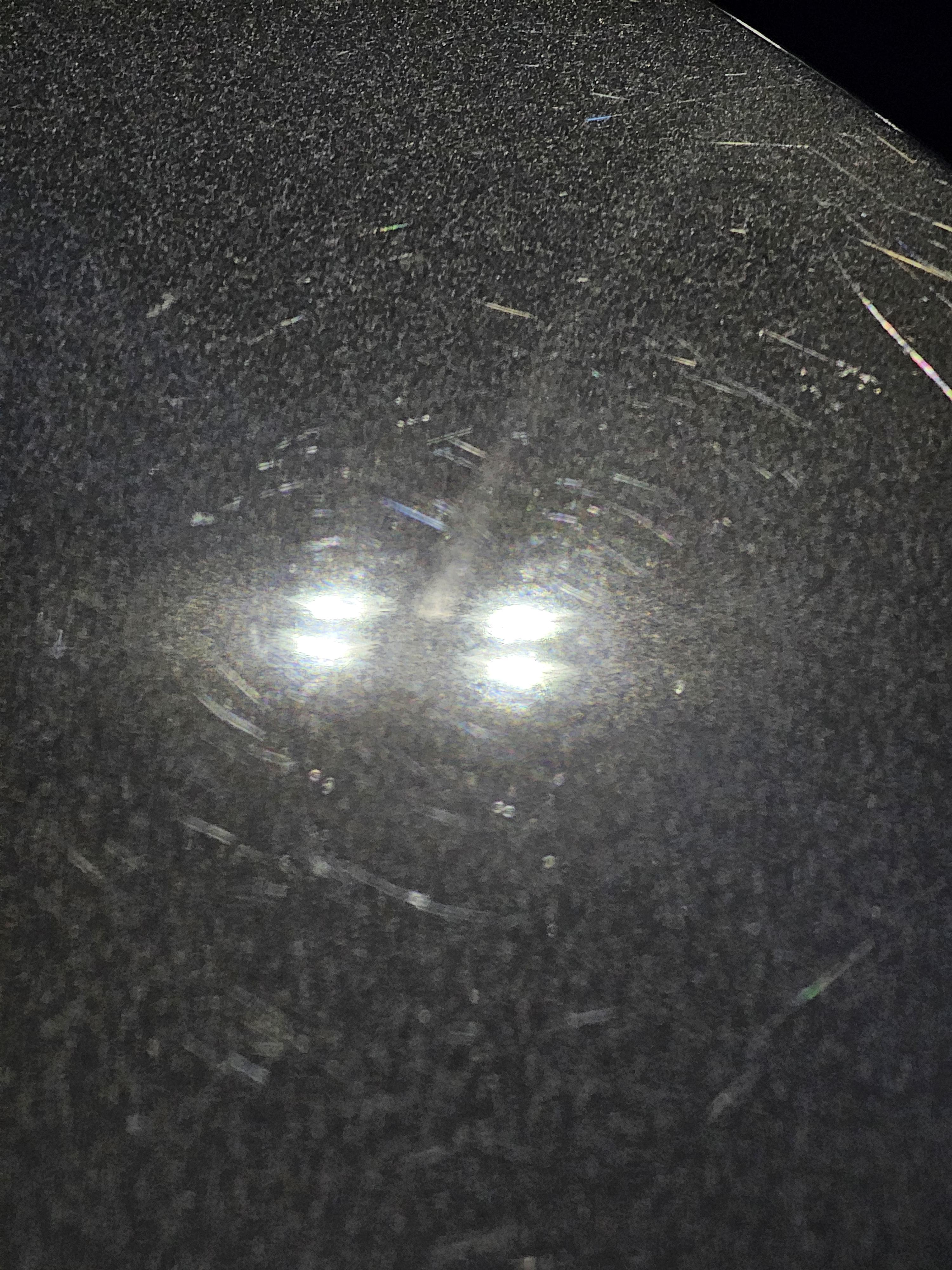 Close-up of black car paint with moderate swirl marks